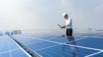 Technician using laptops to monitor the operation of the solar rooftop