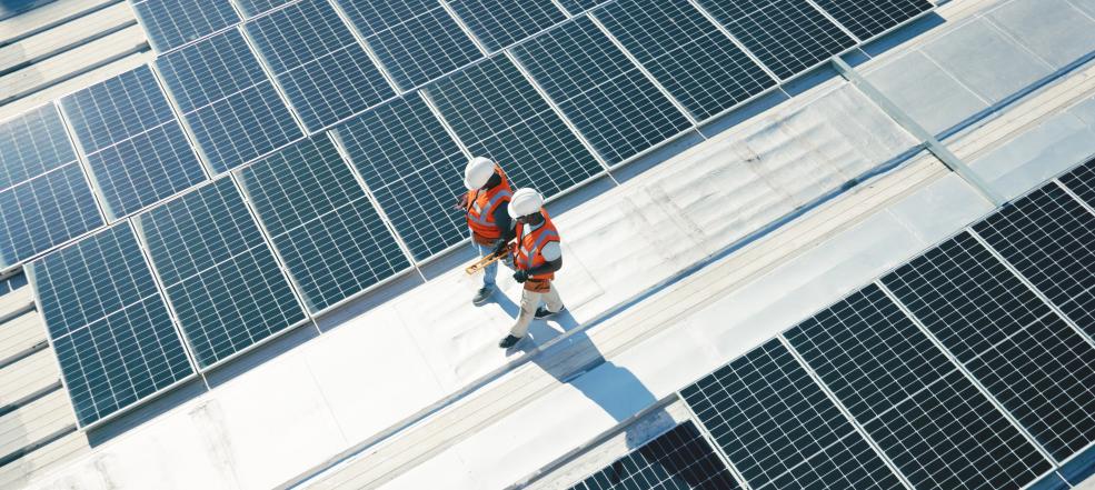 Technicians walking on solar panel roof